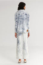 Woman wearing a tie-dye denim jacket and pants on a white background