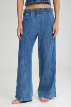 Blue denim wide-leg pants worn by a person on a white background