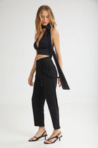 Woman wearing a black outfit with a scarf on a white background