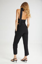 Woman wearing a black jumpsuit with cut-out design on a white background