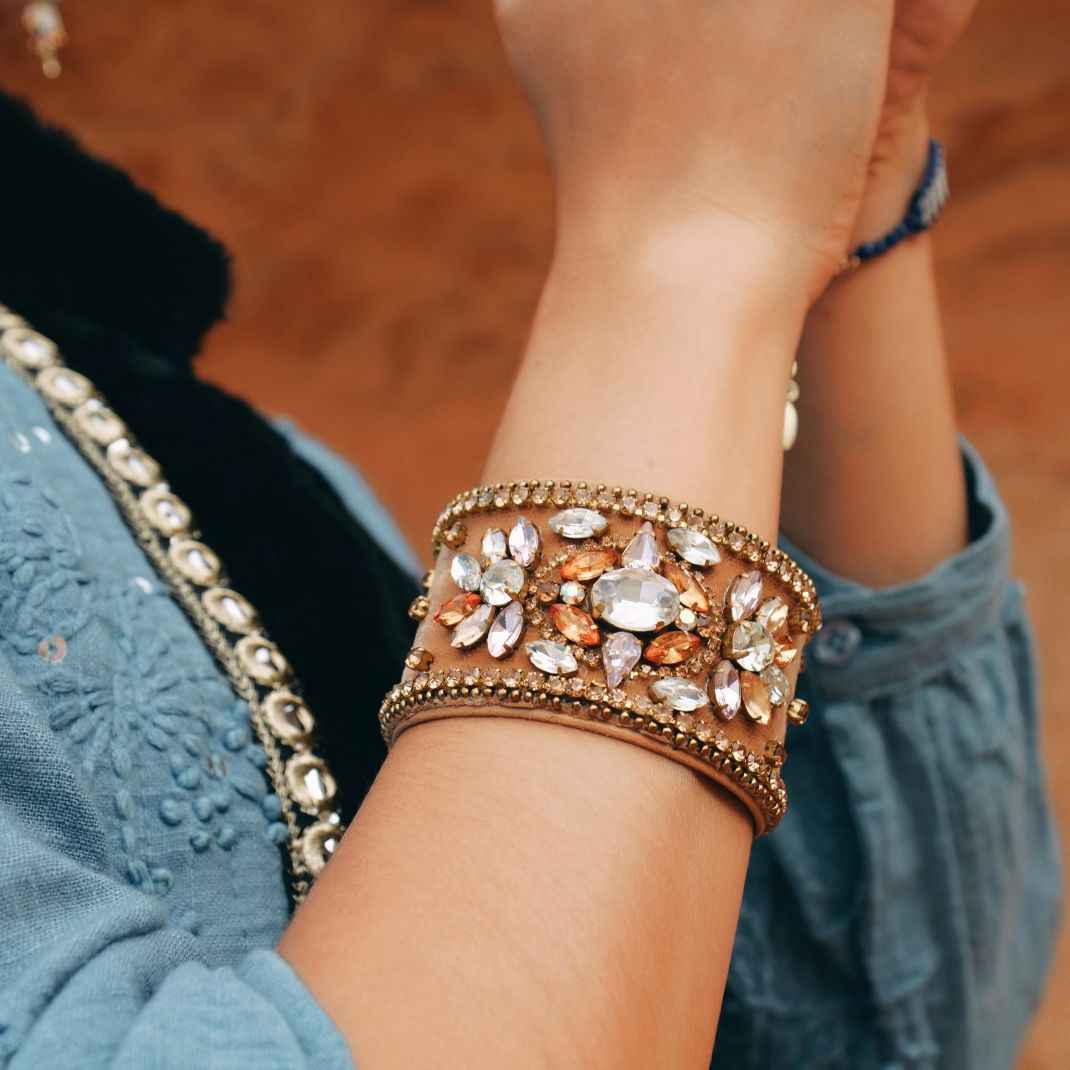 Decorative bracelet with stones on a wrist against a blurred background