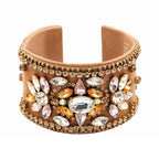 Beige cuff bracelet with crystal embellishments on a white background