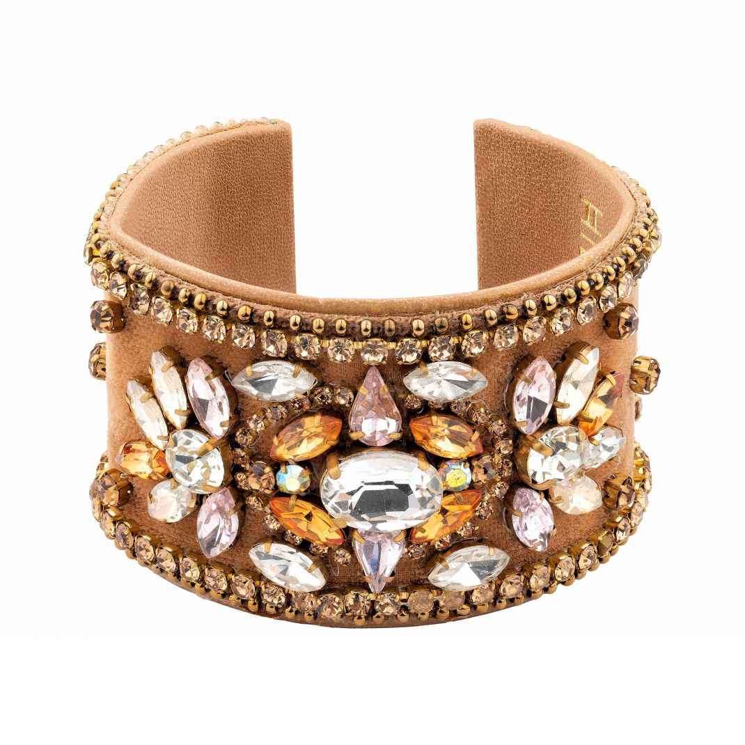 Beige cuff bracelet with crystal embellishments on a white background