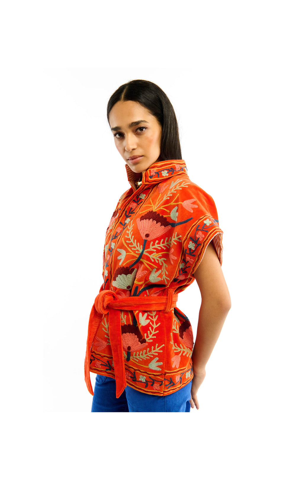 Woman wearing an orange floral patterned shirt on a white background