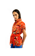 Woman wearing an orange floral patterned shirt on a white background