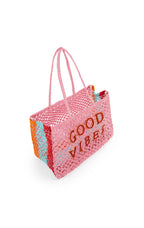 Pink woven bag with 'Good Vibes' text on a white background