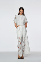 Woman wearing a white lace outfit on a white background