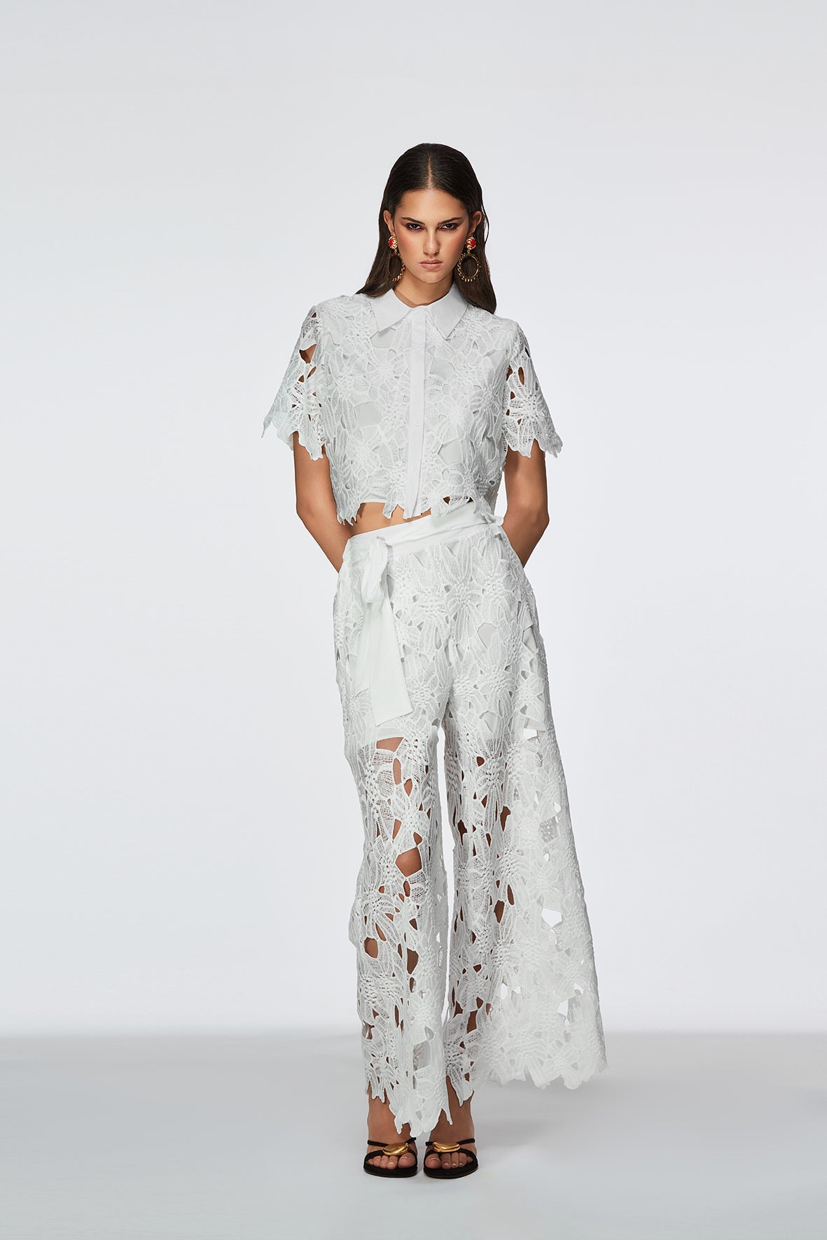 Woman wearing a white lace outfit on a white background