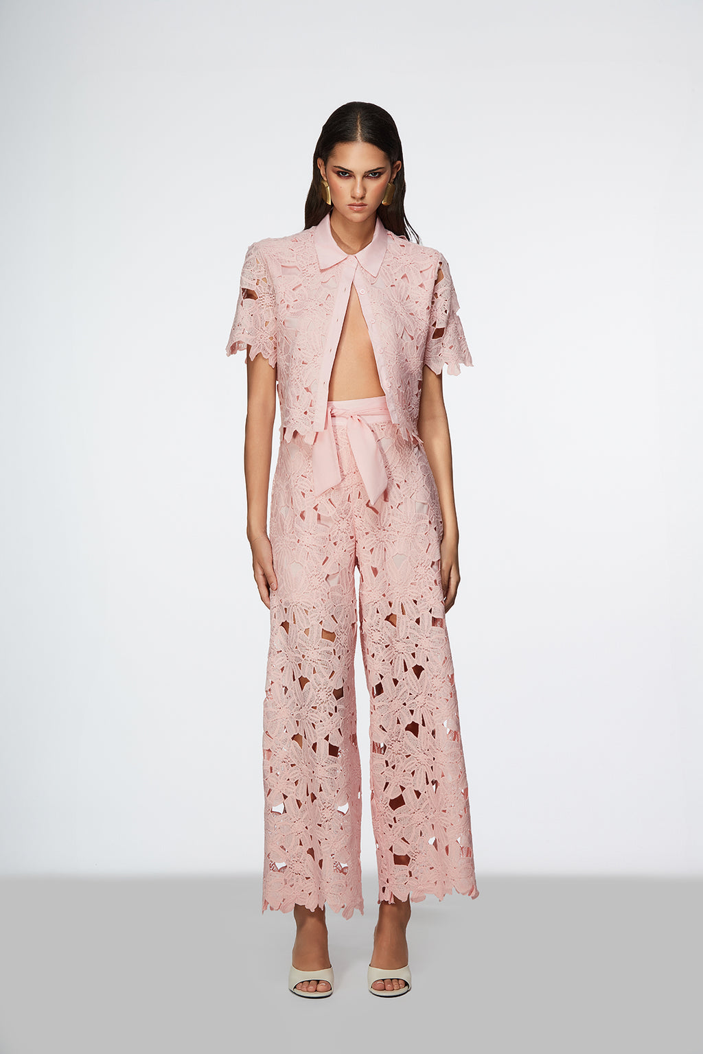 Woman wearing a pink floral outfit on a white background