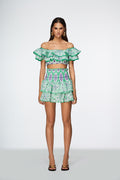 Model wearing a green and white patterned outfit on a white background