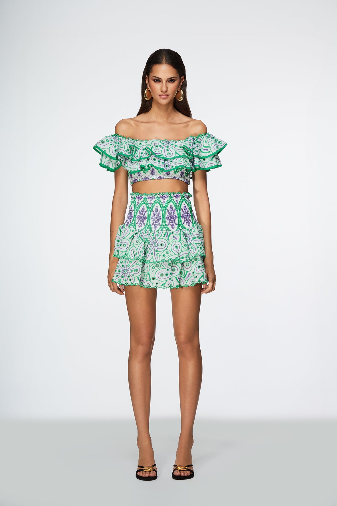 Model wearing a green and white patterned outfit on a white background