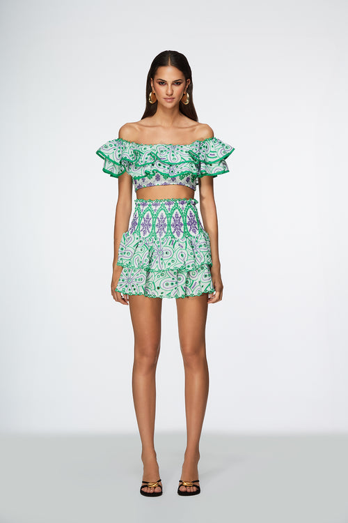 Model wearing a green and white patterned outfit on a white background