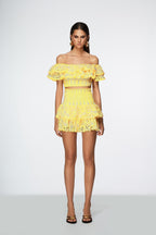Woman wearing a yellow lace outfit on a white background