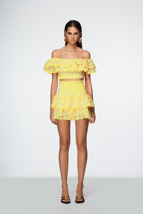 Woman wearing a yellow lace outfit on a white background