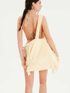 Woman wearing a yellow cover-up over a bikini on a white background