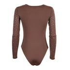 A long-sleeve bodysuit in a solid medium brown color, featuring small white rhinestone embellishments along the sleeves, shown against a plain white background.