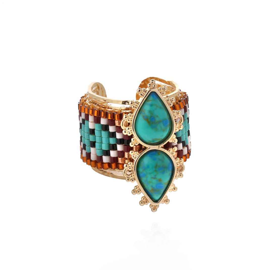 Multicolored beaded cuff bracelet with turquoise stones on a white background