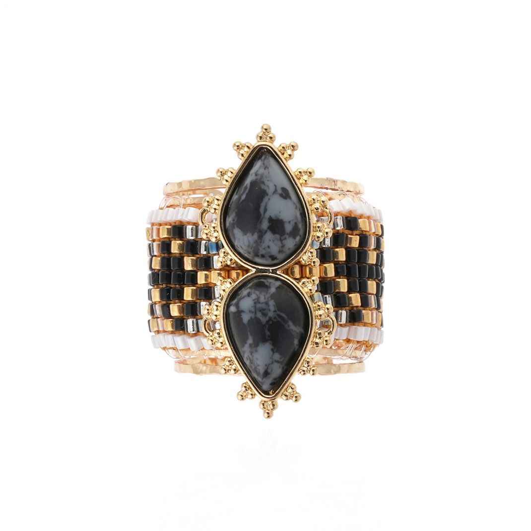 Gold and black checkered bracelet with teardrop-shaped stones on a white background