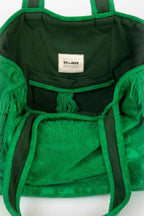 Green fringed bag with a visible brand label on a white background
