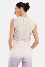Woman wearing a sleeveless top with a visible brand logo on a white background