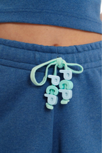 Blue shorts with a green drawstring featuring 'PCP' branding.