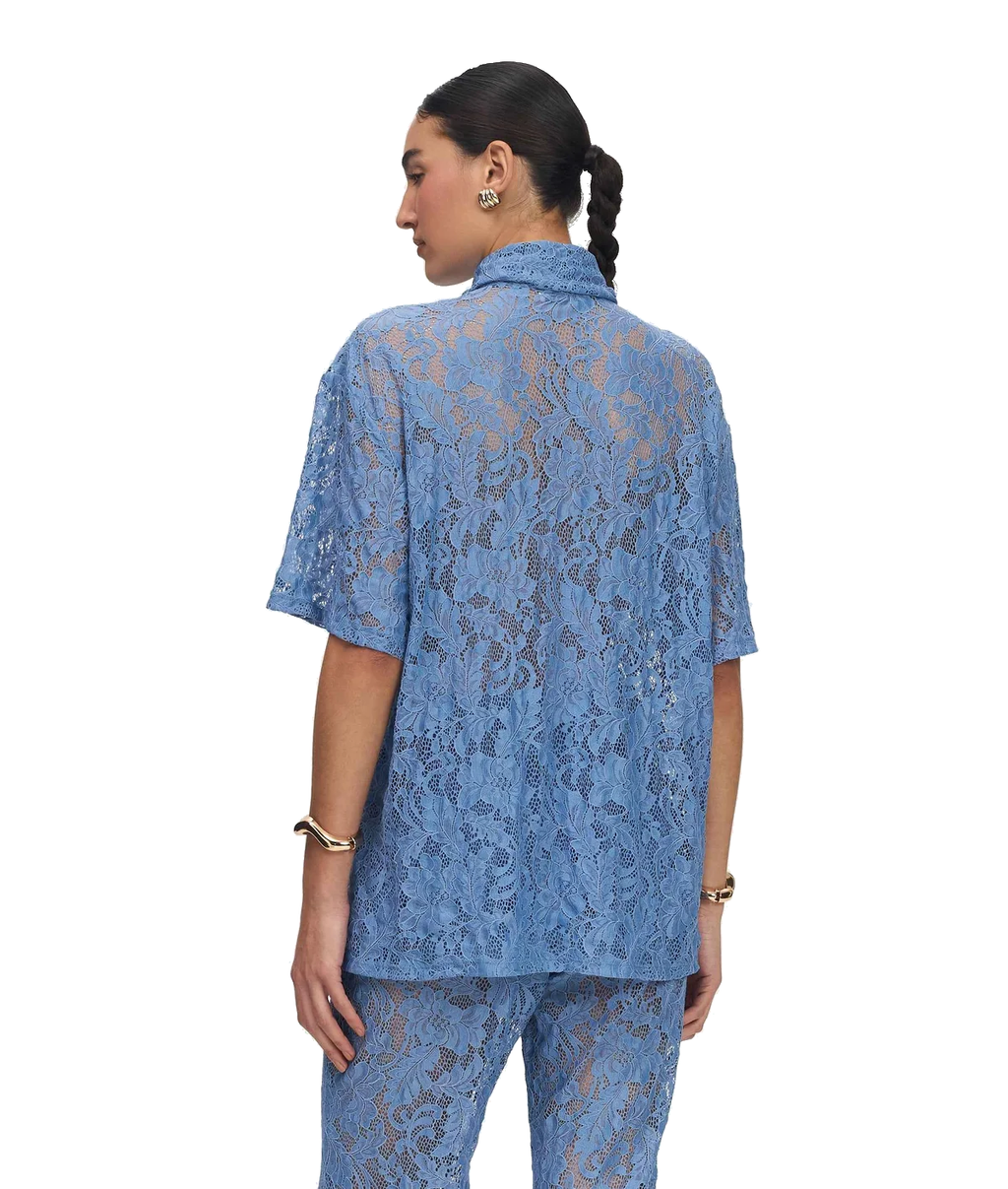 A model shown from the back wearing a matching light blue lace short-sleeve top and pants set against a plain white background.