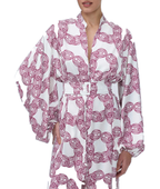 A woman wearing a white kimono-style robe with a bold magenta chain-link pattern, featuring wide sleeves and a matching tie belt, shown against a plain white background.