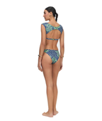 A woman modeling a two-piece bikini from the back, featuring a blue and green patterned design with white polka dots on the bottoms and a matching patterned top with open back straps, set against a plain white background.