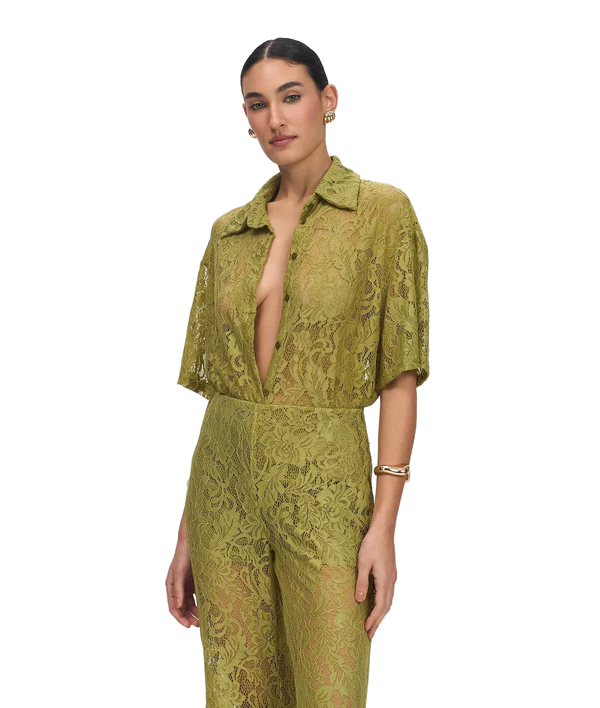 A model wearing a matching olive green lace short-sleeve top and high-waisted trousers set, photographed against a solid white background.