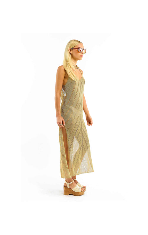 Woman wearing a long, light-colored dress with a white background